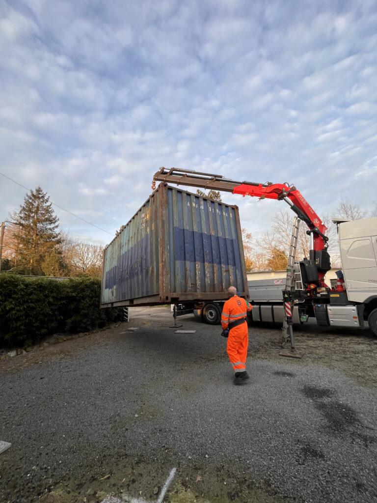 Camion-grue In'Box Container en action, déposant avec précision un container de stockage pour un projet de rénovation à Doullens.