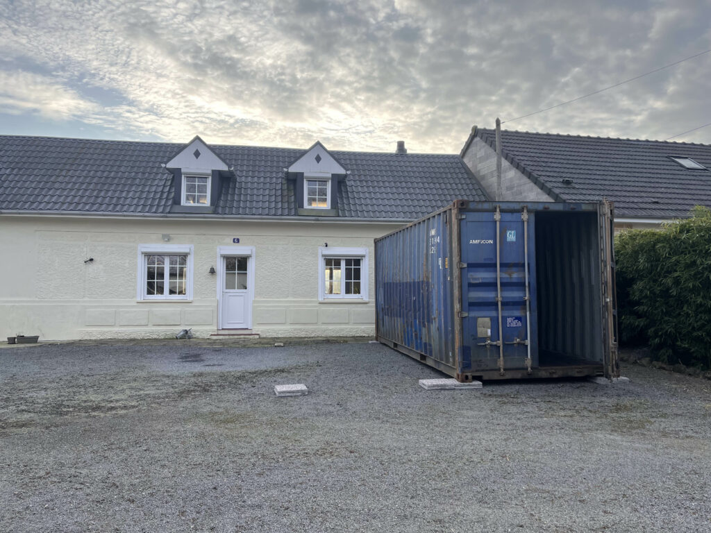 Container de stockage bleu de 20 pieds livré par In'Box Container devant une maison en rénovation à Doullens, Somme.