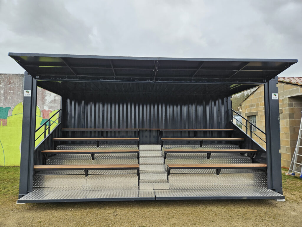 Tribune container rugby Nontron vue de face - Aménagement intérieur par In'Box Container avec bancs bois, escalier central et plancher tôle larmée.