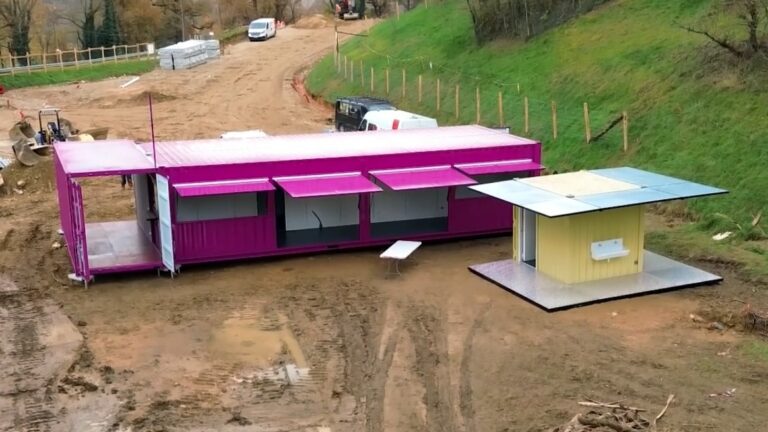 Vue d'ensemble de l'aménagement de containers par In'Box Container au Lac de Champos pour La Forêt des Champos : modules rose (entrée/restauration) et jaune (sanitaires) sur site.