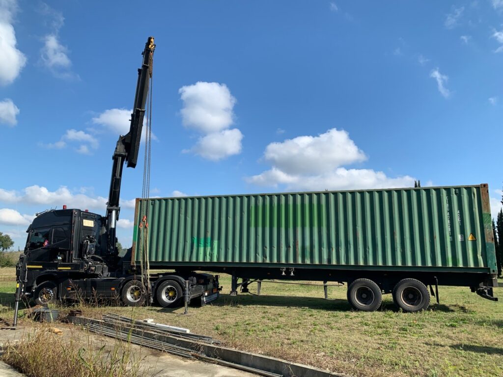Camion-grue livrant un container maritime 40 pieds vert pour le stockage professionnel de Dubois Concept en Haute-Garonne