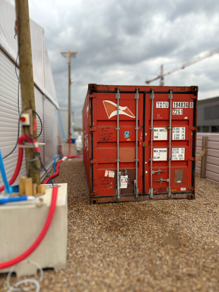 Conteneur de stockage rouge Hamburg Süd sécurisé sur le chantier du temple BAPS à Bussy-Saint-Georges
