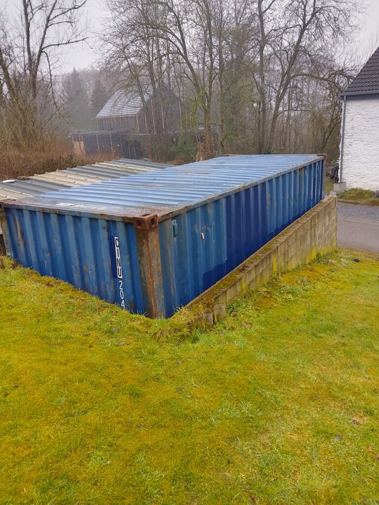 Container garage Manhay vue latérale montrant toit ondulé et intégration terrain