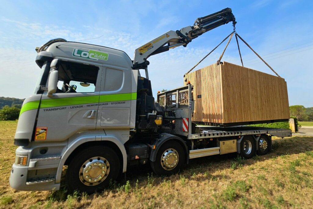 Livraison d'un container avec bardage bois par camion-grue en Dordogne