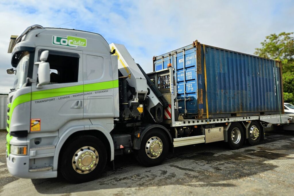 Camion grue de Transport Loc'aster transportant un container 20 pieds In'Box Container pour livraison chez Charente Truck Service Volvo
